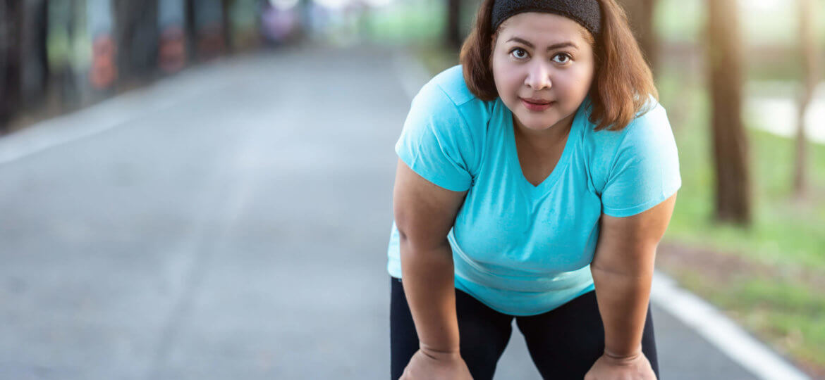 Fat woman feeling tired while running in the park