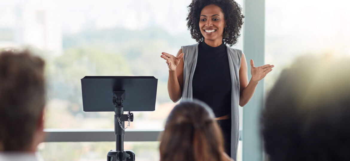 Corporate, businesswoman with presentation and in business meeting in conference room at work. Presenter, happy female speaker and black woman at seminar or workshop speaking with businesspeople