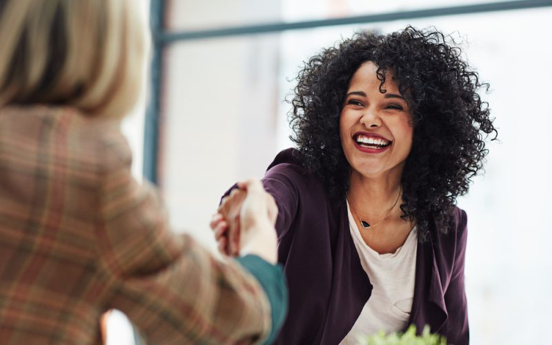 Handshake with a happy, confident and excited business woman or human resources manager and a female colleague, partner or employee. An agreement, deal or meeting with a coworker in the boardroom.