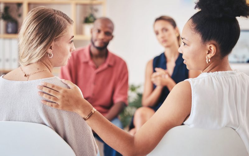 Psychology, mental health and support group with a woman in counseling for help with depression and anxiety with a psychologist she can trust. Communication, community or counselor with a sad patient.
